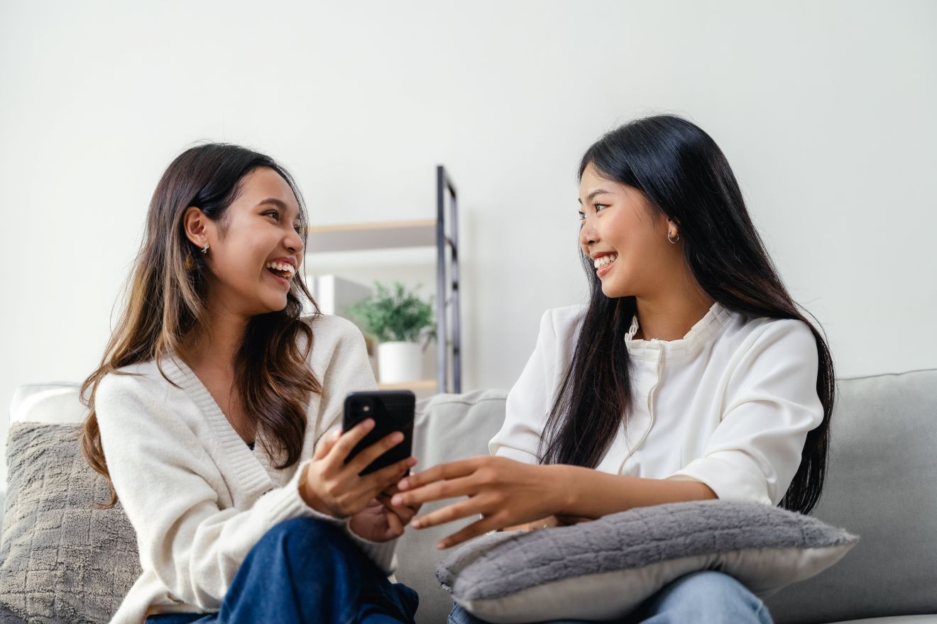 Two women sitting together talking and laughing
