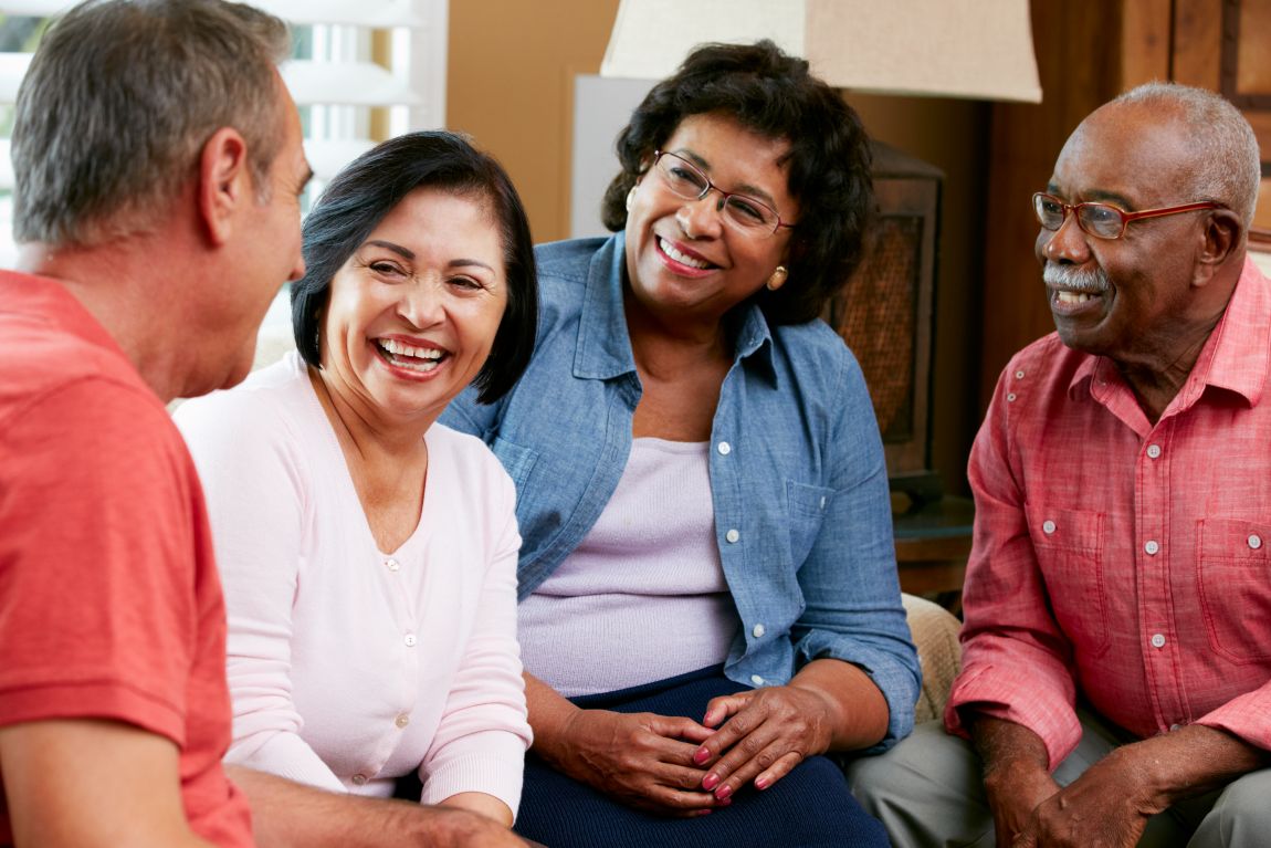 group of adults smiling and conversting with each other