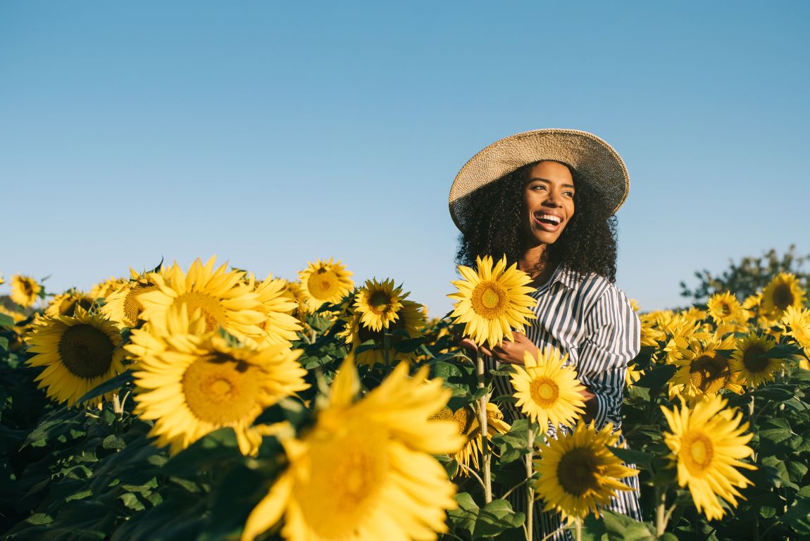 woman smiling in field of sunflowers